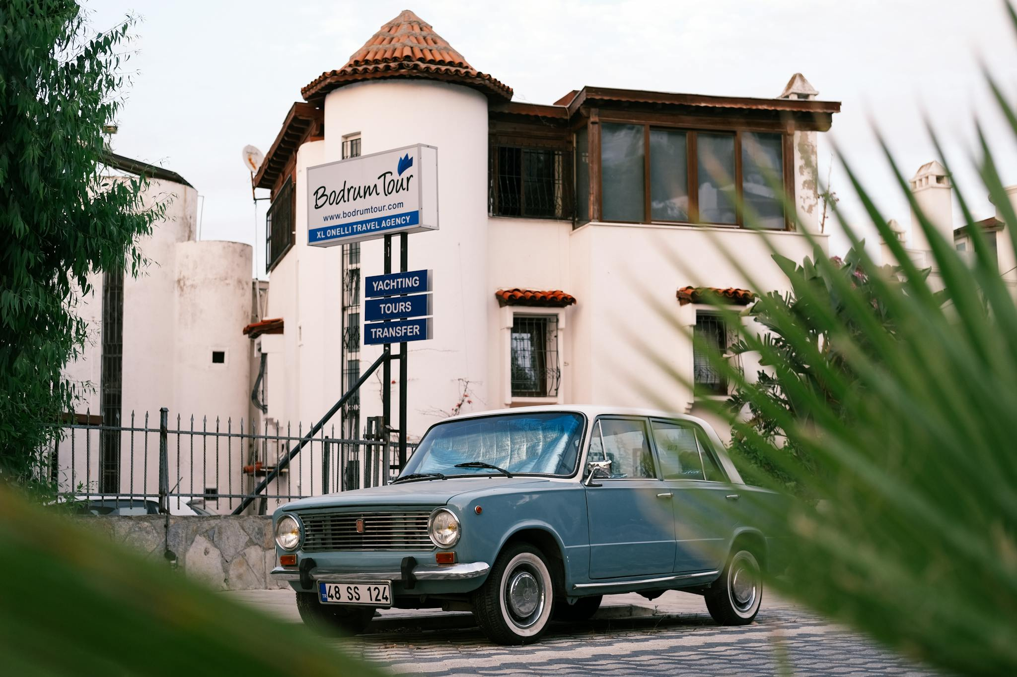 Classic car parked near Bodrum Tour Agency, showcasing retro automotive style.